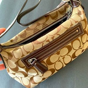 COACH Small brown clutch purse with logo tag.